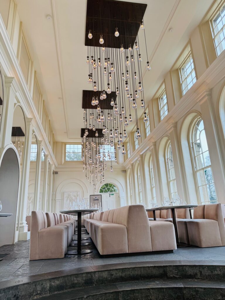 Look into the Orangery with lightbulbs suspended from the ceiling.