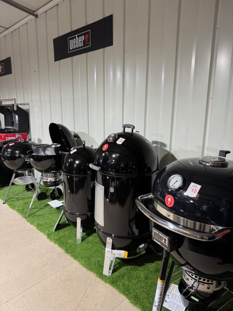 Indoor shot of 5 black weber bbqs for display.